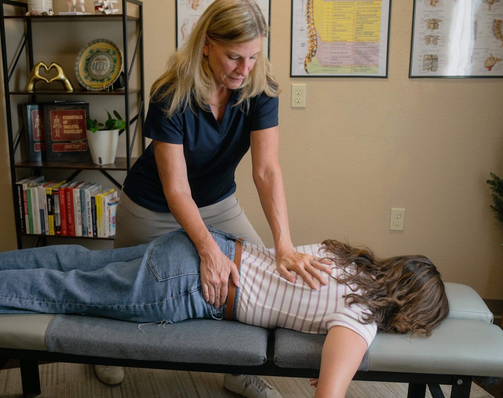 Dr. Emily performing a firm, precise low-back adjustment for a patient.