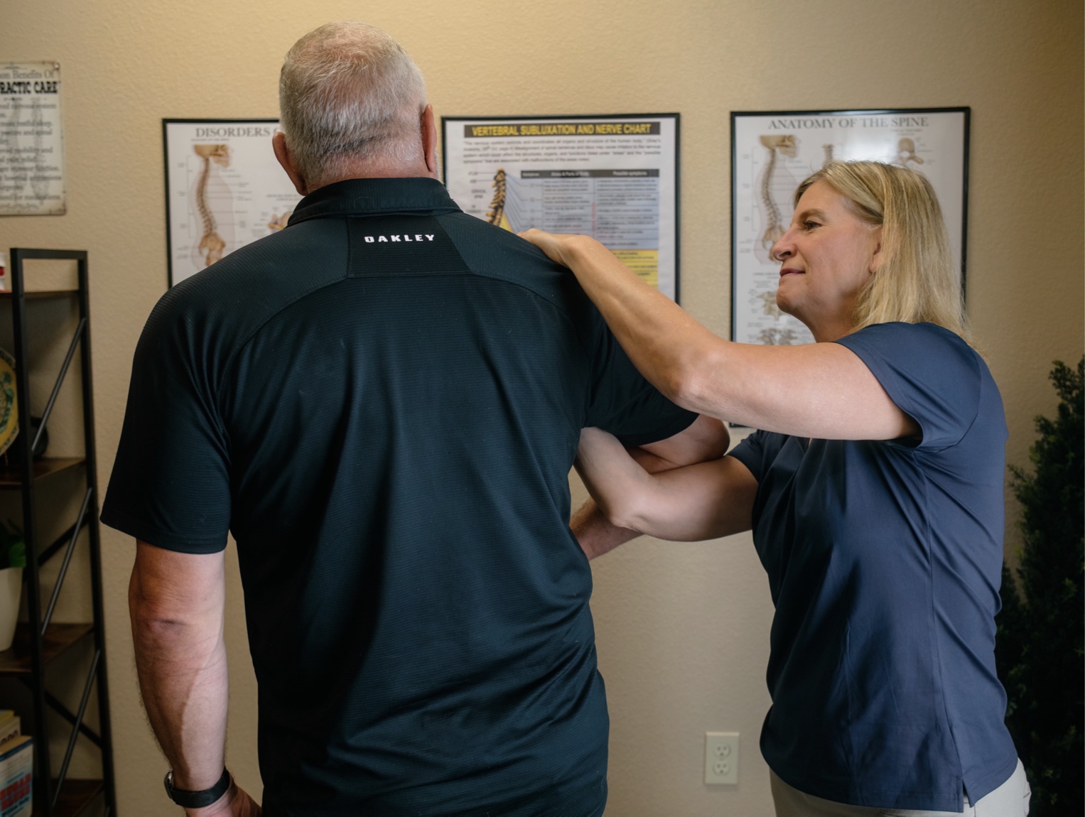 Dr. Emily performing a shoulder adjustment on an active adult patient.